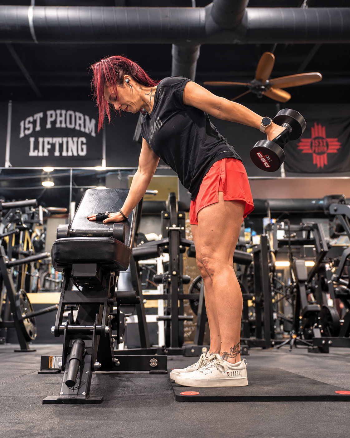 Heather performing a dumbbell strength exercise at the gym